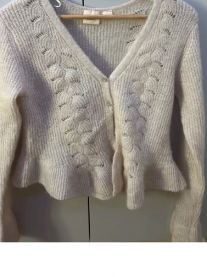 Ljusbeige kofta från Gina Tricot - Slutsåld fin ljusbeige kofta från Gina Tricot med volangkant. Första bilden är lånad men den ser exakt ut så fast lite längre pga storleken. Koftan är i L men skulle mer säga att den sitter som en M/S. Säljer då den inte kommer till användning💞💞💞