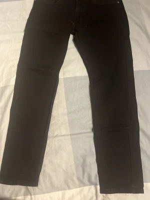 Levi’s 512 W31 L30 - Säljer ett par svarta jeans från Levi's med klassisk rak passform. Jeansen har fem fickor, bälteshällor och Levi's ikoniska läderpatch bak i midjan. Perfekta till en avslappnad stil och funkar året runt.
