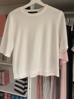 Vit topp från Vero Moda - Klassisk vit topp från Vero Moda med rund halsringning och halvlånga ärmar. Enkel och stilren design som passar till det mesta. Tillverkad i mjukt material för en bekväm känsla.