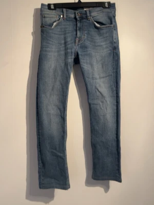 Ljusblå raka jeans från tiger of sweden - Snygga ljusblå jeans med rak passform och klassisk femficksdesign från tiger of sweden. Jeansen har normal midja och är tillverkade i denim med lätt tvättad look. Perfekta för en avslappnad stil och passar till det mesta i garderoben.