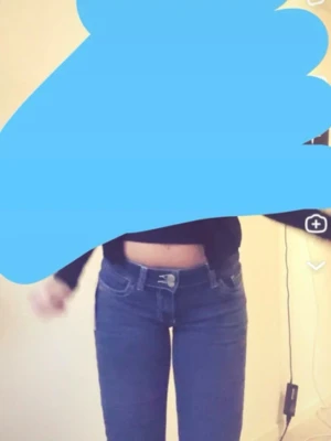 Flared Low rised blå Nelly jeans - Säljer ett par blå  jeans med vita kontrastsömmar och klassiska fem fickor. Jeansen har låg midja och dragkedja med knapp framtill. Snygga detaljer på bakfickorna och stretchigt denimtyg för en bekväm passform.