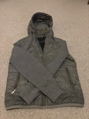 massimo dutti cardigan - Min kille säljer sin grå cardigan från Massimo Dutti. Jackan har huva, quiltad framsida och baksida i glansigt material samt mjuka, stickade ärmar. Han säljer då den blivit för liten, köpt för ca 2 år sen. Passar någon som är ca 175-185cm lång. Jackan är felfri och har inte några synliga skador. Priset baserats på att den ej går att köpa längre, nypris var 2999kr. Skriv om ni har funderingar.