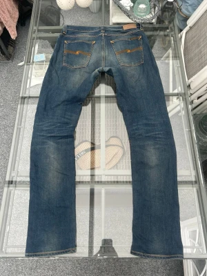 Nudie Jeans Tube Tom W32/L34 – slim fit mörkblå - Säljer ett par Nudie Jeans Tube Tom i mörkblå tvätt (Turner Shade Blue). Riktigt snygg slim fit som sitter bra och funkar till allt.  Lite naturligt slitage som ger en skön vintagekänsla, men inga hål eller skador. Bra skick!  • Storlek: W32 L34 • Slim fit • 98% ekologisk bomull, 2% elastan (skön stretch) • Klassiska Nudie-detaljer  Perfekta vardagsjeans eller till en clean outfit.