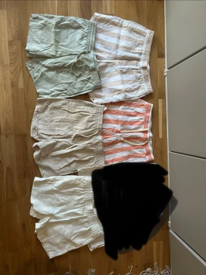 Fem par linne-shorts i olika färger - Fem par snygga shorts i linne, perfekta för sommaren. Färgerna är ljusgrön, vit, vit med beige ränder, vit med orange ränder och helvita.  Perfekta för en avslappnad och trendig stil. Storlekarna varierar.  PRIS 50kr styck eller alla för 200kr Hör av er vid funderingar eller fler bilder! 