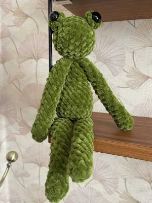 Virkad groda 29 cm handgjord - Handvirkad groda i mjukt chenillegarn med långa armar och ben samt stora ögon, en lekfull och mysig figur som passar perfekt som present eller dekoration. Varje exemplar är unikt och gjort för hand. Höjd ca 29 cm. Mjuk, kramvänlig och lätt i vikt.