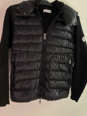 Moncler Cardigan  - Äkta Moncler cardigan i storlek S. Jackan är i väldigt bra skick den enda defekten på jackan är en knapp som lossnat (syns på första bilden) luvan går att ta bort om man vill ha jackan som en cardigan istället. Pris kan sänkas vid snabb affär