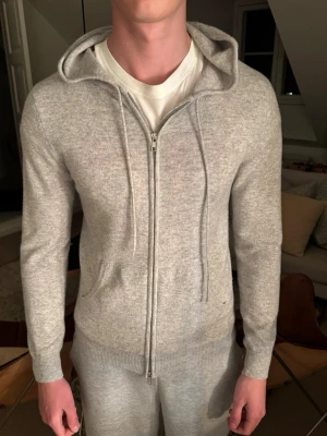 Ljusgrå zip-hoodie i mjuk ullmix - Snygg ljusgrå zip up hoodie, varan är i bra skick. Säljer då den inte kommer till användning.  Pris kan diskuteras