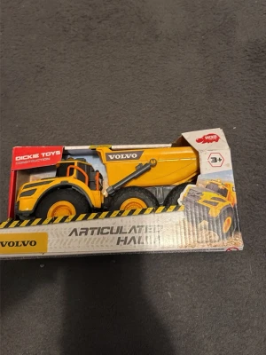 Volvo leksakslastbil gul - Säljer en gul och svart leksakslastbil från Volvo, modell Articulated Hauler. Tillverkad i plast och kommer i originalförpackning. Passar barn från 3 år och uppåt. Perfekt för den som gillar byggfordon och maskiner.