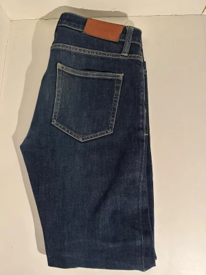 Mörkblå raka jeans med kontrastsömmar - Snygga mörkblå ACNE jeans. Passar perfekt till dig som gillar lite mer slim stilen. Priset kan diskuteras!