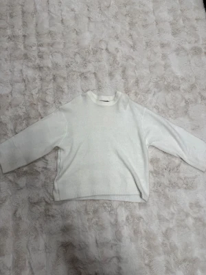 Vit stickad tröja från 157 - Klassisk vit stickad tröja från 157 med rund halsringning och raka ärmar. Tröjan har en enkel och stilren design som passar perfekt till många olika outfits. Materialet känns mjukt och bekvämt mot huden. Priset kan diskuteras 💓