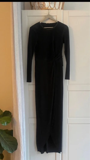 Svart långklänning - Svart långklänning från NLY Eve med långa ärmar. Klänningen går lite omlott nere vid benen.  Klänningen har en smickrande passform och är tillverkad i ett mjukt material som ger en lyxig känsla.  Endast använd några få gånger. Fint skick. 