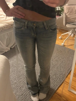 Ljusblå bootcut jeans från cheap monday  - Säljer ett par ljusblå bootcut jeans med snygg slitning och klassisk femficksmodell. Jeansen har normal midja och är tillverkade i mjukt denimtyg med lite stretch för skön passform. Perfekta till sneakers eller boots. Ganska små i storlek passar en xs/s. Jag är 163 de sitter lite för långt på mig. 