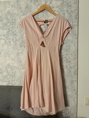 Ljusrosa klänning med öppen rygg  - Söt ljusrosa klänning med öppen rygg. Aldrig använd med lappen kvar, storlek S