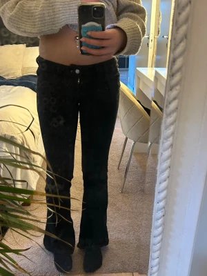 Svarta bootcut jeans med lila detalj - Säljer ett par svarta low waist bootcut jeans från cheap monday. Jeansen är i storlek 27/30 och köpta i slutet på augusti. Använda ett fåtal gånger då jag inte gillar hur de sitter på mig.
