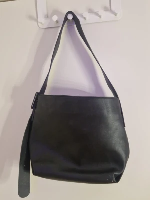 Axelväska kappahl - Använd fåtal gånger. Finns en liten spricka i lädret vid ett av hålen på axelbandet. Köpt här på vinted men kommer ej till användning. SKICKAR INTE MED INSTABOX