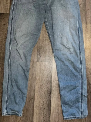 Ljusblå Replay jeans  - Säljer ett par ljusblå Replay jeans med raka ben och tydliga kontrastsömmar längs sidorna. Jeansen har klassisk femficksdesign och är tillverkade i denim. Perfekta för en avslappnad och trendig look. Pris kan sänkas vid snabb affär. Snabb frakt.