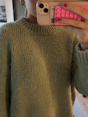 Ljusgrön stickad tröja från Zara - Mysig ljusgrön stickad tröja från Zara med rund halsringning och ribbade muddar. Tröjan har en avslappnad passform och är gjord i ett fluffigt, mjukt material som passar perfekt för kyligare dagar.