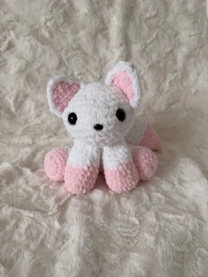 Virkad vit och rosa räv - Handvirkat gosedjur i mjukt garn, gjort med omtanke. Passar som dekoration eller present – ej för små barn. 