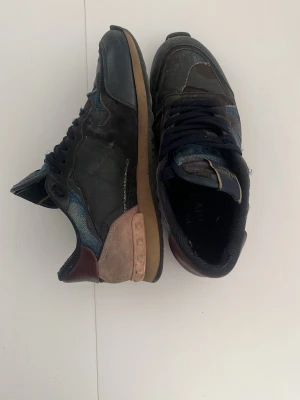 Valentino Garvani Rockrunners - Valentino Garvani Rockrunners i mörkblå färg i storlek 40 (passar 41). 7/10 skick ingen låda. Har lite slit i skorna. Hör av er om frågor eller bilder.