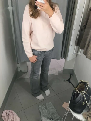 Grå bootcut jeans med låg midja - Säljer ett par gråa bootcut jeans med låg midja och klassisk femficksdesign. Jeansen har en avslappnad passform och är tillverkade i denim med lätt tvättad look. Perfekta för en casual och trendig stil.