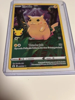Pikachu Pokémonkort 2021 - Säljer ett samlarkort med Pikachu från Pokémon, utgivet 2021. Kortet har färgstark design med Pikachu i en djungelmiljö och är inplastat i ett skyddsfodral. Perfekt för dig som gillar Pokémon eller samlar på kort! 005/025!