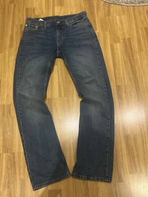Blå bootcut jeans från Levi's - Klassiska blå jeans från Levi's 527 med bootcut passform och fem fickor. Jeansen har en snygg tvättad look och är tillverkade i slitstark denim. Perfekta för dig som gillar en tidlös och avslappnad stil. Köpte från Levis butik för inte länge sedan
