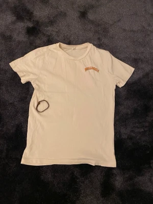 Vit t-shirt med Mallorca-tryc( ingår armband) - Säljer en vit t-shirt med färgglatt Mallorca-tryck på ryggen och liten text fram. T-shirten har rund hals och korta ärmar. Perfekt för dig som gillar semester vibes och vill ha något chill och snyggt i garderoben.