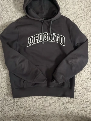 Svart Arigato hoodie med tryck - Hej! Säljer en grå aktig hoodie från Arigato, skicket på tröjan är bra och har ni frågor är de bara o skriva priset kan självklart diskuteras! Storleken står inte och kommer ej i håg den men passar mig som Small