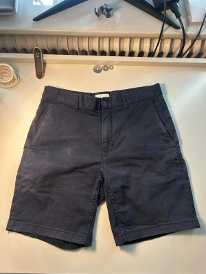 Mörkblå bomullsshorts från East West - Snygga mörkblå shorts i bomull från East West. Shortsen är i st 28 och har en klassisk shortsdesign! Finns att köpa på brothers för 600kr. Skriv gärna vid frågor eller funderingar!
