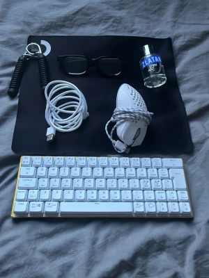 Vit kompakt tangentbord och gamingmus - Säljer ett stilrent vitt kompakt tangentbord med guldkant och en matchande vit gamingmus med hål för bättre grepp. Perfekt för gaming eller studier. USB-kabel och svart musmatta ingår. Tangentbordet har låg profil och modern design. Och jag har lagt till några saker på priset 