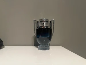 Paco Rabanne Invictus Legend (halva kvar) - Snygg parfymflaska från Paco Rabanne i form av en pokal. Flaskan är gjord av glas med en mörkblå ton och har detaljer i silverfärgad metall. Perfekt för dig som gillar stilrena och unika designer på dina parfymer.