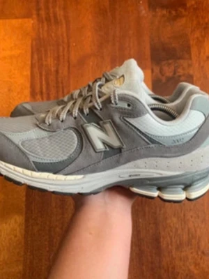 Grå New Balance 2002R sneakers - Ett par fina new balance skor som är använda fåtal gånger. Passar perfekt till vädret som vi har nu och är fresha. 