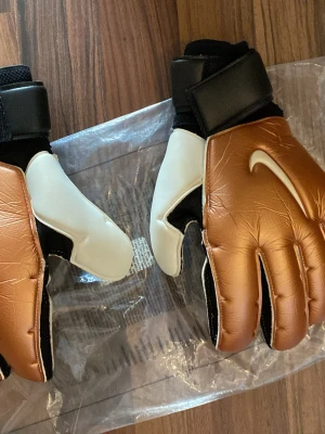 Nike målvaktshandskar brons/vit - Ett par helt nya Nike Målvaktshandskar med finger skydd som man kan ta ut och in