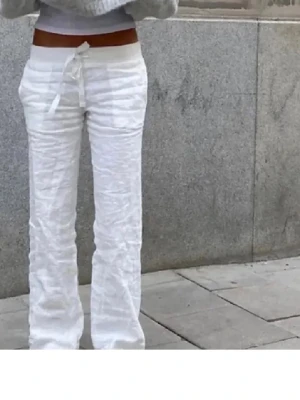 Vita linnebyxor  - Säljer ett par vita linnebyxor med avslappnad passform och dragsko i midjan. Byxorna har raka ben och en enkel, stilren look som passar perfekt till sommaren. Materialet är luftigt linne som ger en skön känsla.