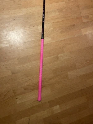 Salming Aerolite innebandyklubba - Säljer en Salming Aerolite innebandyklubba med svart skaft och rosa grepp. Klubban har en stilren design med Salming-logga och Aerolite-tryck i rosa. Längd 101 och flex 27, ord pris 1300/1200 ish, använd på typ 3 matcher och några få träningar, säljer pga behöver längre klubba