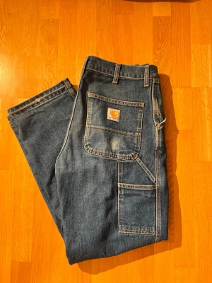 Blå Carhartt jeans med stora fickor - !!Har sytt ner byxändarna!!! (se sista bilden!).             32W 32L