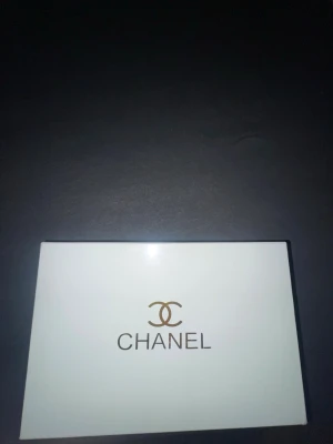 Chanel bag, dustbag och box - Säljer en elegant svart, guld Chanel bag tillsammans med en vit dustbag med klassisk Chanel-logga och vitt Chanel box. 
