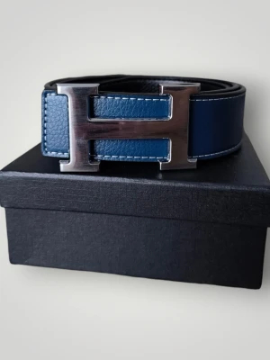 H-Belte Blått - Snyggt blåt skärp med H-spännet i metall. Perfekt accessoar för att lyfta vilken outfit som helst