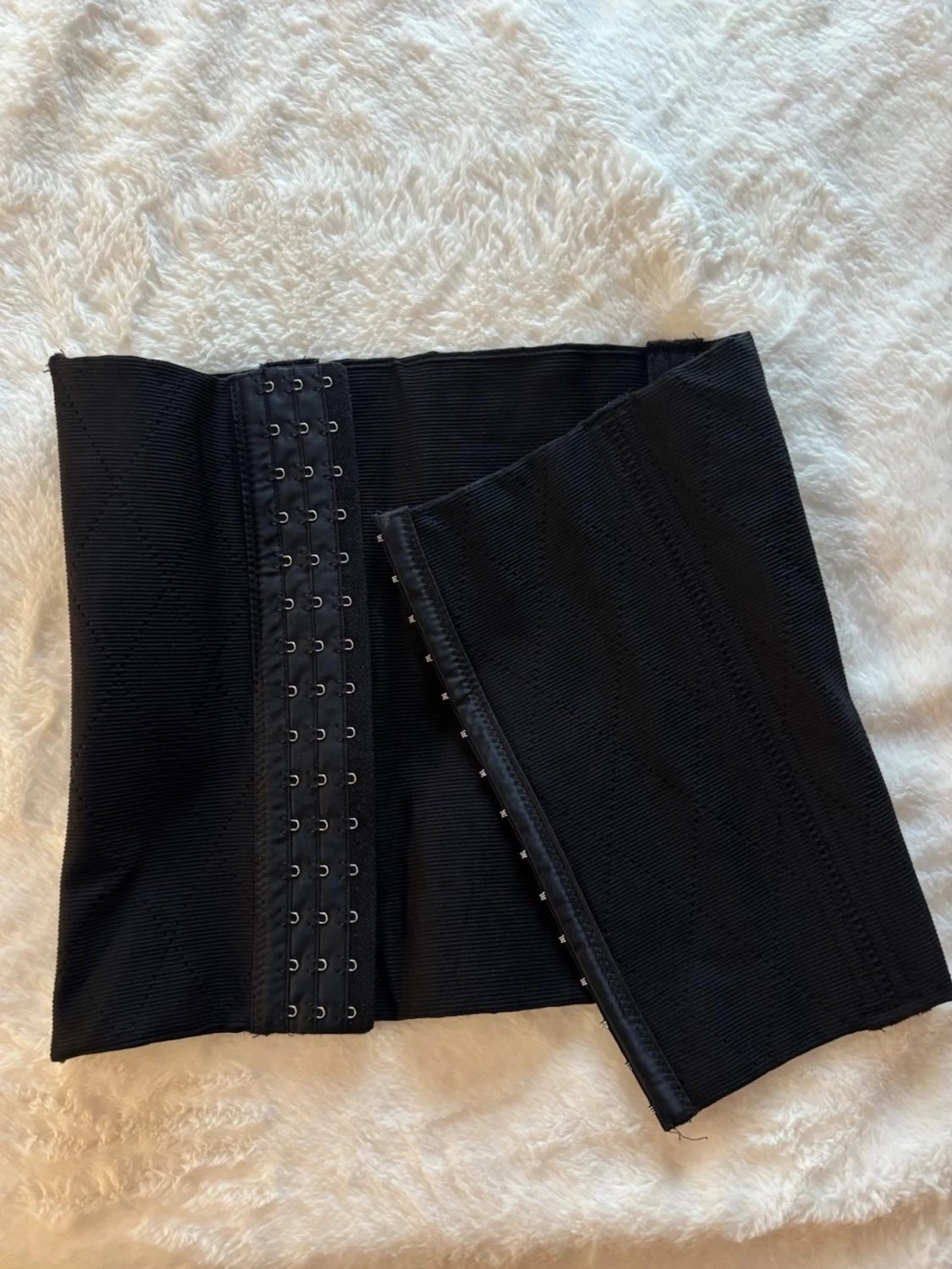 Svart midjekorsett med hyskknäppning