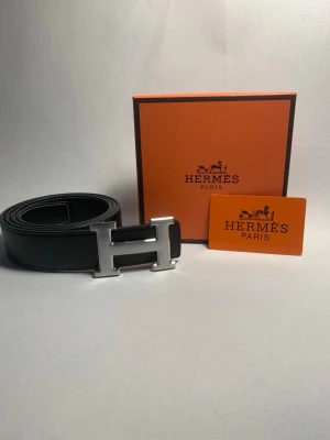 Svart H bälte i läder  - Snyggt svart skärp i läder med H-spänne. Vid köp ingår det box,skärp,kort. Vid funderingar och frågor så är du varmt välkommen att kontakta mig