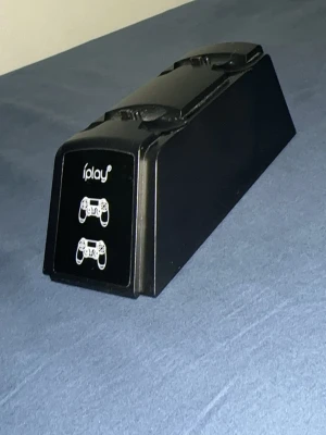 iPlay laddstation för handkontroller - Säljer en svart laddstation från iPlay för två handkontroller. Snygg och stilren design i plast, perfekt för att ladda dina spelkontroller smidigt och hålla ordning på gamingbordet.