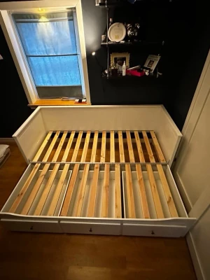 Hemnes säng - Säljer en vit dagbädd i trä med tre stora utdragslådor undertill. Sängen har ribbotten och kan dras ut till dubbelsäng. Perfekt för gästrum eller tonårsrum och ger smart förvaring för till exempel sängkläder eller kläder. Kostar 5000kr ny