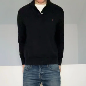 Ralph Lauren Half zip Cardigan - Säljer en sjukt fet svart Half zip fast med knappar ifrån Ralph Lauren. Tröjan är i bra skick och sitter i strl M. Hör gärna av er vid frågor eller funderingar!!