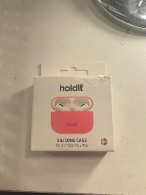 Holdit silikonfodral AirPods Pro 2/Pro - Snyggt rosa silikonfodral från Holdit till AirPods Pro 2/Pro. Fodralet är supertunt, endast 0,8 mm, och stötdämpande. Tillverkat av veganskt material och levereras i återvunnen förpackning. Perfekt för att skydda dina hörlurar med stil. Varan är öppnad men inte använd. Jag råkade nämligen få fel modell💞