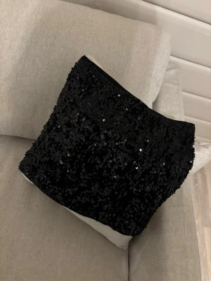 Svart minikjol - Säljer en svart minikjol täckt med paljetter. Använd en gång