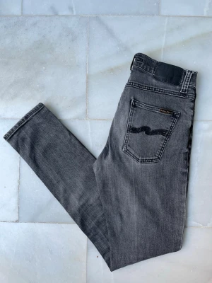 Grå jeans från Nudie Jeans - Snygga grå Nudie Jeans. Modellen är Lean Dean. Notera att det är ett litet hål vid gylfen (bild 6)——————————————————————————                                                          📐| Storlek: 29-32                                                  👖| Märke: Nudie Jeans                                         🔎 | Skick: Bra skick (litet hål)                                  💵 | Ny Pris: 1599kr                                                 ✍🏻 | Skriv om du har några frågor
