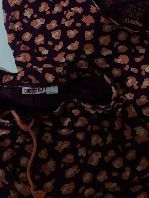 Mörklila pyjamas med leopardmönster - Säljer en tvådelad pyjamas från pepperts! i mörklila med orange och ljusgula leopardfläckar. Setet består av långärmad tröja och byxa med dragsko i midjan. Mjukt och bekvämt material, perfekt för mysiga kvällar.