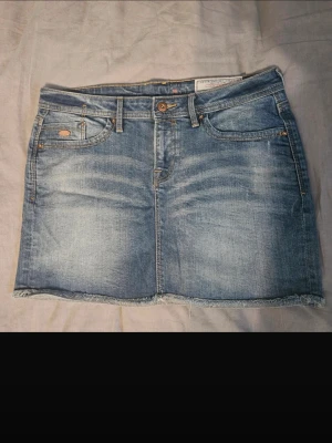 Low waist jeanskjol - Säljer min jätte fina vintage low waist jeans kjol med sömmar på fickorna i storlek 38 då den inte längre kommer till användning,den är i jättebra skick och fin nu till sommaren hör av er vid frågor.Midjemåttet rakt över är 42cm och längden på kjolen är 34cm kjolen är köpt i pålen därav vet jag inte vilket märke den är ifrån.