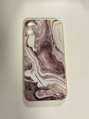 Oanvänt iPhone 12-skal – Lyxig brun lila marmordesign  - Ge din iPhone en lyxig makeover med detta supersnygga skal i marmordesign med vackra lila, rosa och skimrande detaljer. Skalet är helt oanvänt och i perfekt nyskick – bara väntar på en ny ägare! 💜  🌸 Elegant och trendig design 🌸 Passar perfekt till iPhone 12 🌸 Skyddar mobilen mot vardagligt slitage 🌸 Lätt och bekvämt att hålla i  Ett perfekt skal för dig som älskar en stilren, feminin och exklusiv look utan att betala nypris. ✨  📦 Skickas snabbt vid köp!  Först till kvarn! 💕