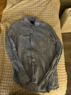 Ljusblå linne skjorta  - Jättefin skjorta som användts sparsamt är i storlek M (se exakt storlek på bild 2) men skulle säga att den är mer mot en S, klassisk i modellen 100% linne, och nypriset ligger vid 1000-1500kr ungefär. Inga defekter , lite skrynklig på bild men försvinner ju om man stryker den. (Hund finns i hemmet) 